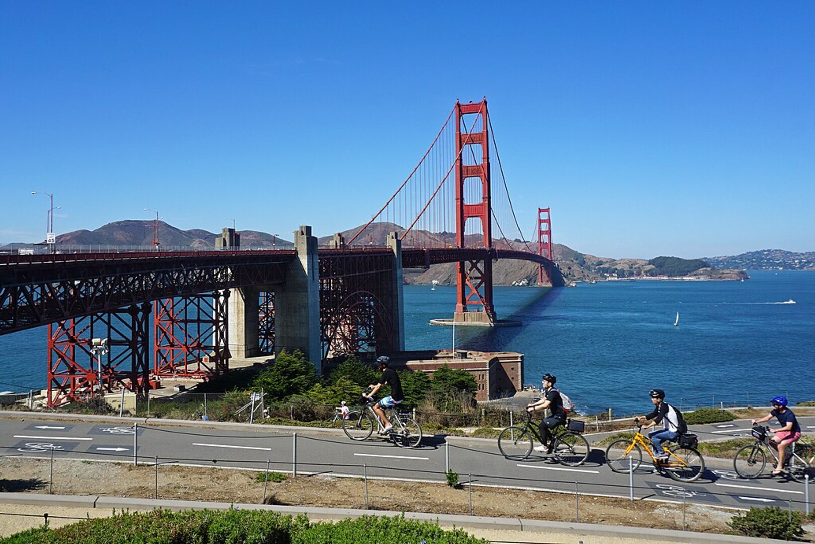 Cyclists riding under Golden Gate Bridge